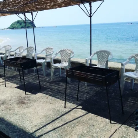 志賀島の浜辺に並ぶBBQ台と海の風景